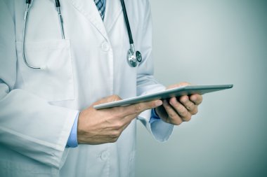 bir tablet bilgisayar kullanan doktor adam
