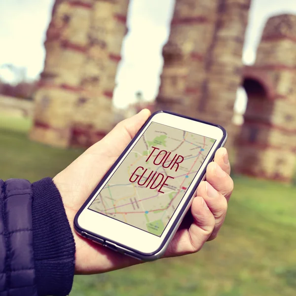 Man met een smartphone met de tekst tour guide — Stockfoto