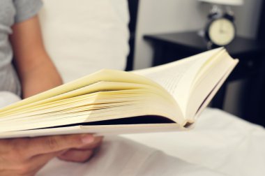 genç adam yatakta kitap okuma