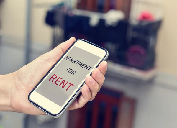 Text apartment for rent in a smartphone — Stock Photo, Image