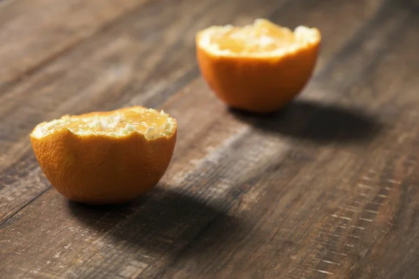 Naranja cortada por la mitad sobre una mesa de madera — Foto de Stock