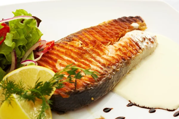 Жареный лосось со свежим салатом и лимоном — стоковое фото