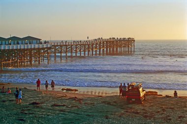 Kaliforniya 'da gün batımında insanlarla iskele