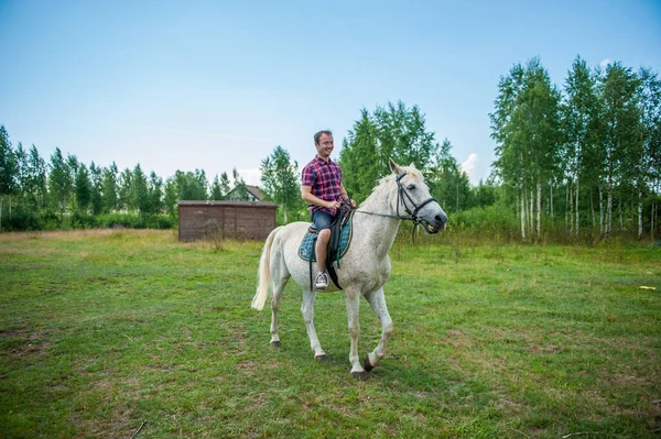 Ung man rider en häst — Stockfoto