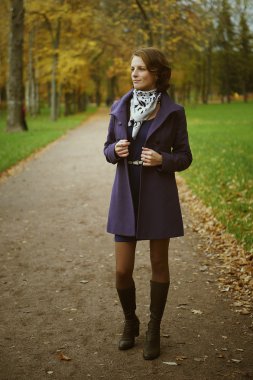 Parkta poz veren güzel genç bir kadın.