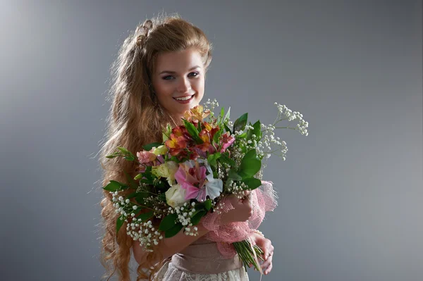 Hübsche Frau im Kleid mit Blumenstrauß — Stockfoto