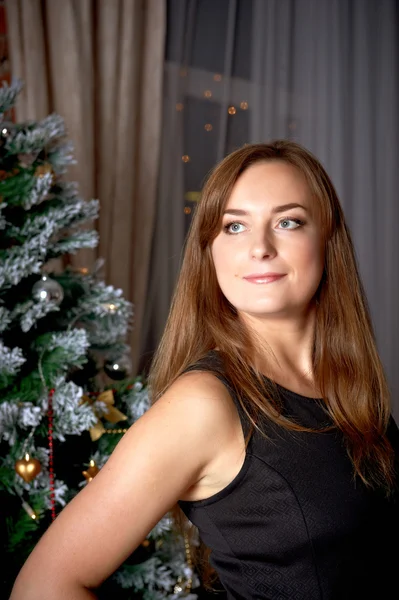 Lächelnde Frau im Kleid über Weihnachtsbaum Hintergrund — Stockfoto