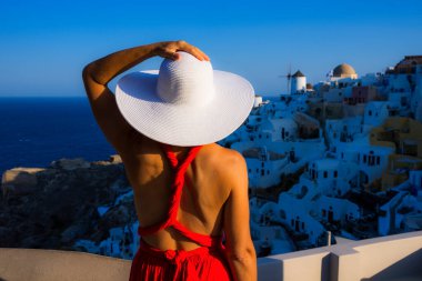Oia, Santorini, Yunanistan 'da beyaz şapkalı kadın