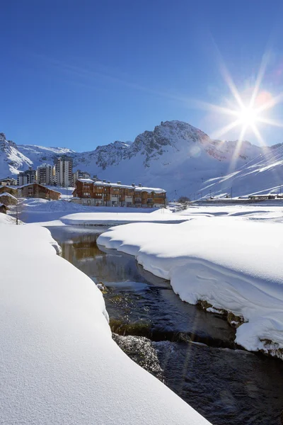 Tignes by med solen och creek — Stockfoto