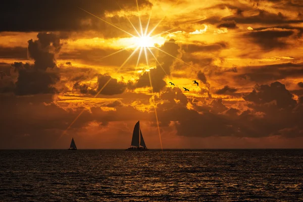 Barco silhueta dourar um pôr-do-sol colorido vívido — Fotografia de Stock