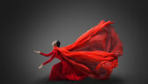 Woman in red dress with flying fabric