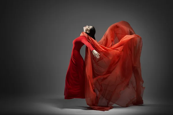 Mujer en vestido rojo con tela voladora Imagen de archivo