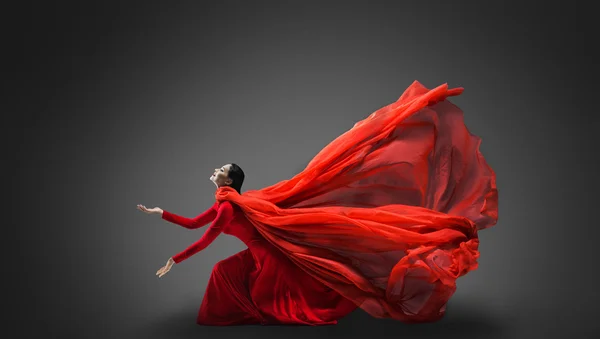 Mujer en vestido rojo con tela voladora Imagen de archivo