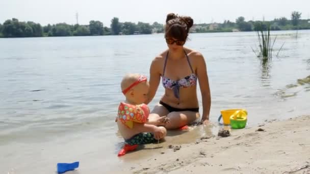妈妈带着孩子在河岸上 — 图库视频影像