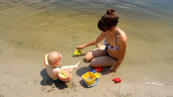 Mãe com uma criança na margem do rio — Vídeo de Stock