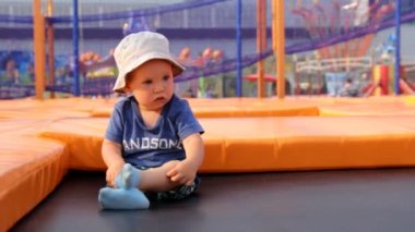 Çocuk bir trambolin üzerinde oturur