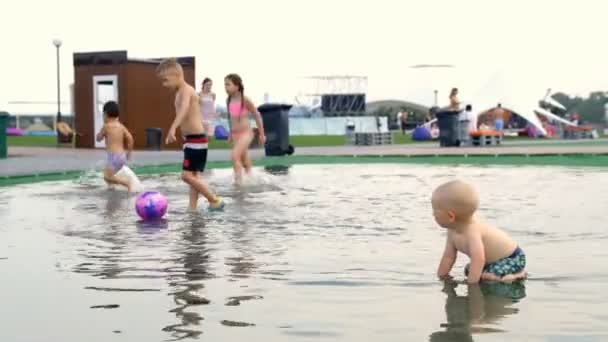 Kinder rennen um die Pfütze — Stockvideo