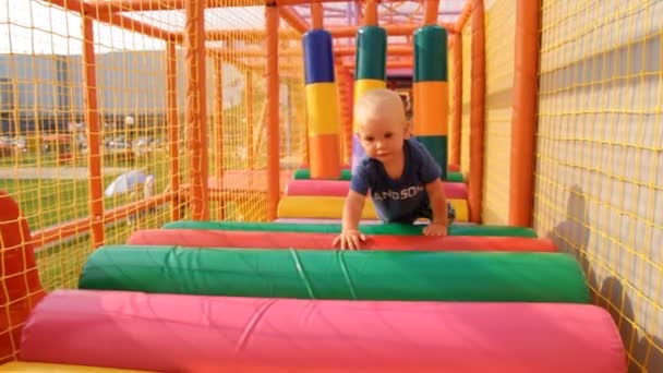 Il bambino striscia su un morbido, Parco giochi per bambini — Video Stock