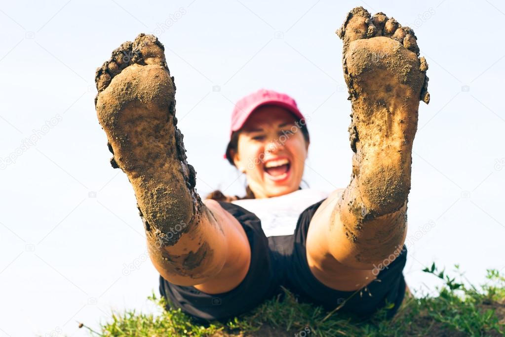 Girl lying on the grass her dirty feet. 