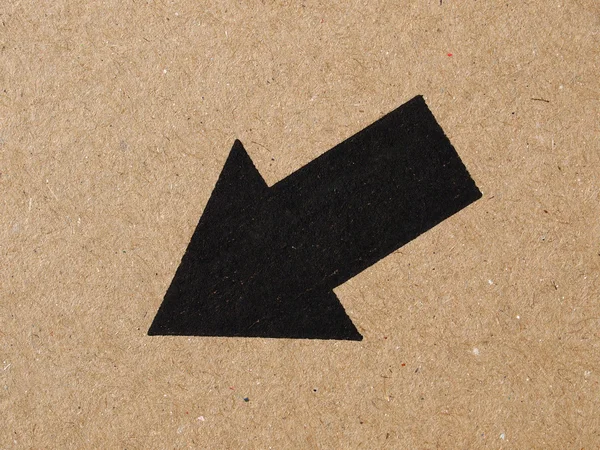 Black arrow on cardboard — Stock Photo, Image