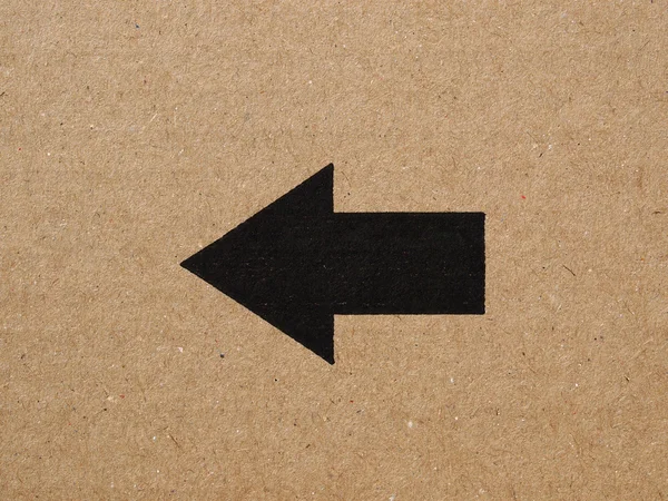 Black arrow on cardboard — Stock Photo, Image