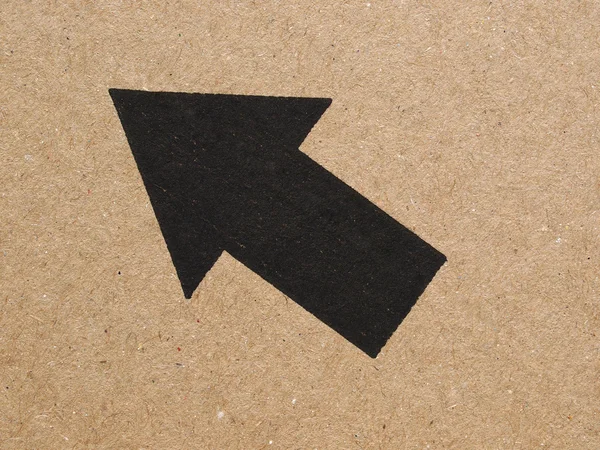 Black arrow on cardboard — Stock Photo, Image