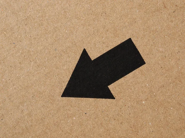 Черная стрела на картонке — стоковое фото