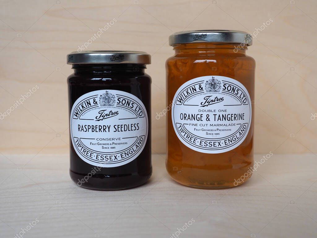 TIPTREE, UK - CIRCA DECEMBER 2020: Jar of Wilkin and Sons raspberry seedless conserve and orange and tangerine fine cut marmalade