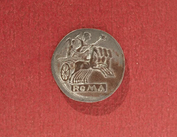 Αρχαίο Ρωμαϊκό Νόμισμα Πάνω Από Ένα Κόκκινο Φόντο — Φωτογραφία Αρχείου