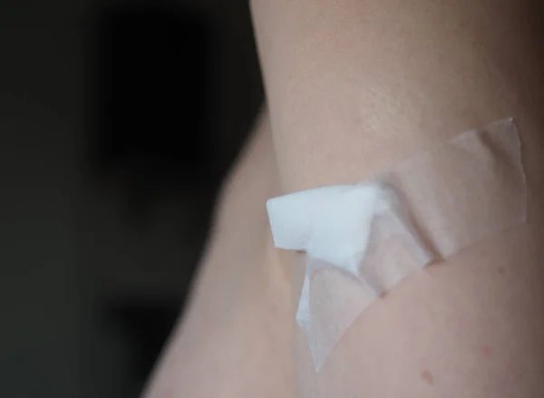 adhesive bandage on a freshly vaccinated arm