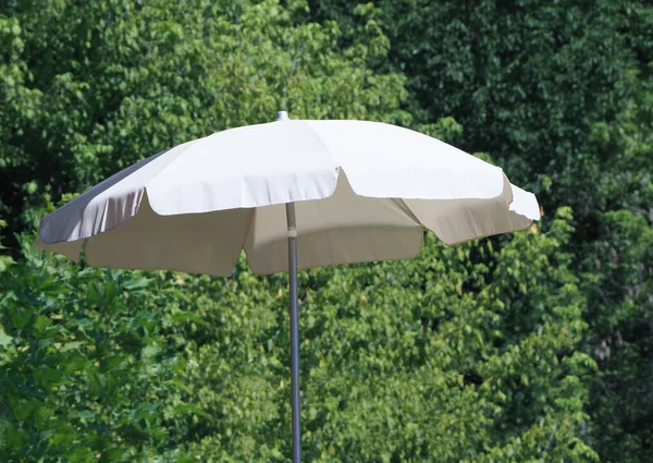 緑の木の背景を持つ夏の太陽の傘 — ストック写真