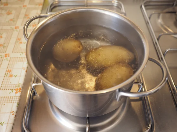 Saucepot med potatis på spis — Stockfoto