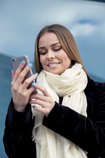 Menina feliz mensagens de texto em um telefone inteligente — Fotografia de Stock