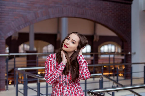 Jovem mulher bonita em camisa xadrez posando na Universidade — Fotografia de Stock