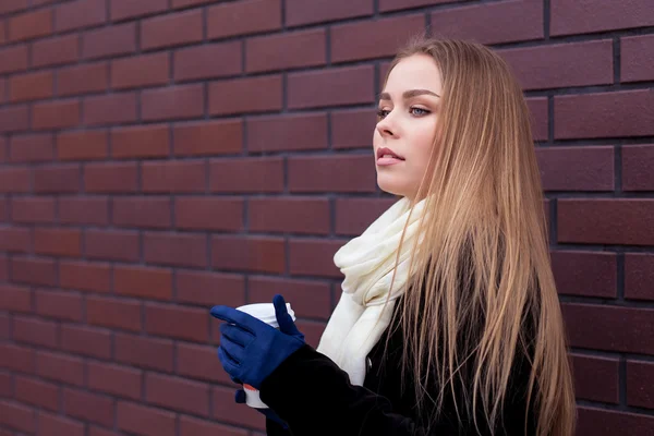 Jolie blonde sur fond de mur de briques dans la rue — Photo