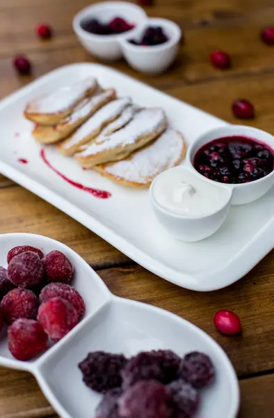 Deliziose frittelle con lamponi, mirtilli e fragole. Spruzzato con zucchero a velo . — Foto Stock