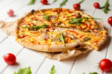 Roka ve parmesan pizza kadar yakın ahşap arka plan beyaz üzerine dilimlenmiş. İtalyan mutfağı.