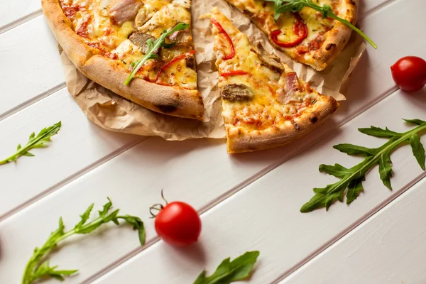 W plasterkach zachwycający smaczne pizza z warzywami na biały drewniany stół — Zdjęcie stockowe