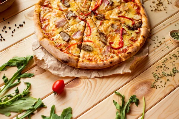 Smaczne pizze i warzywa na drewnianym stole — Zdjęcie stockowe