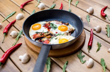 Pan kızarmış yumurta, pastırma ve domates ekmek karanlık masa yüzeyi, üstten görünüm ile