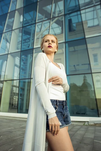 Mooie blonde jonge vrouw lopen op de straat — Stockfoto