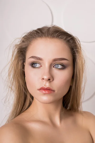 Portrait of a beautiful woman with long blonde hair on grey — Stock Photo, Image