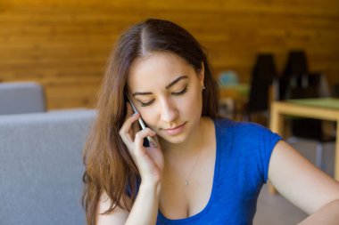 mutlu genç kadın kahve ile rahat giysiler içinde kanepede oturan