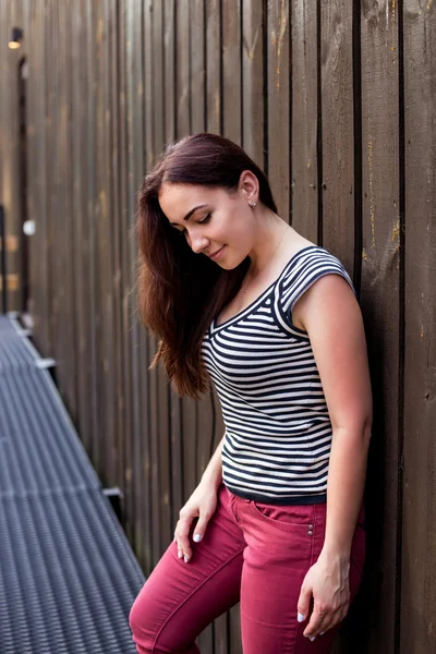 Portret van positieve vrouw op een houten achtergrond — Stockfoto