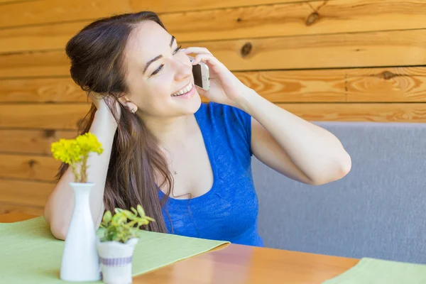 Gelukkige vrouw praten op mobiele telefoon alleen zittend in moderne coffeeshop interieur — Stockfoto