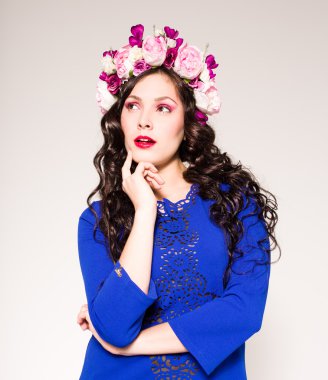 Saç stili ve saçlarında çiçekler olan manken.