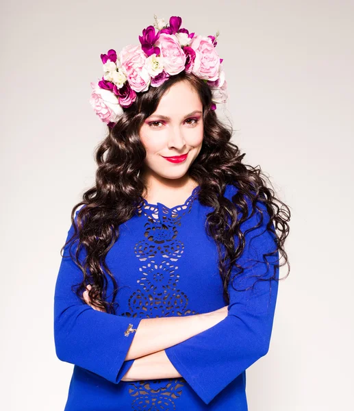 Mannequin de mode avec une grande coiffure et des fleurs dans ses cheveux. — Photo