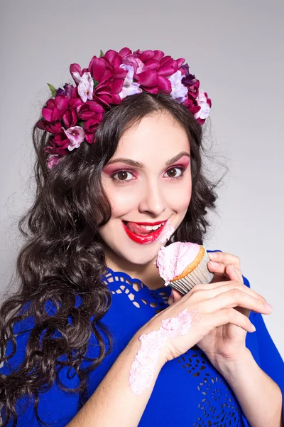 Young happy woman eating a cupcake — Stock Photo, Image