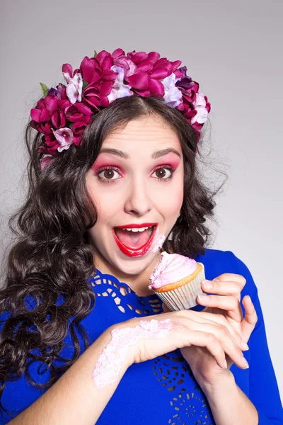 Vacker kvinna försöker äta en cupcake — Stockfoto
