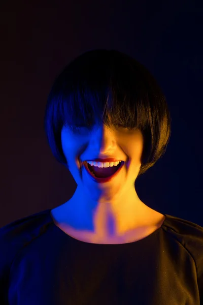 Mujer feliz en una peluca en el estudio sobre un fondo oscuro —  Fotos de Stock
